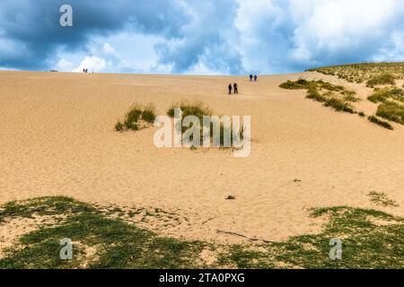 People walking down a sand dune in Sleeping Bear National Park, Michigan. Sleeping Bear Dunes National Lakeshore. Glen Arbor Township, United States Stock Photo