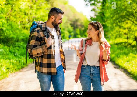 Happy couple hiking in nature on sunny day. Couple enjoying their vacation. Stock Photo