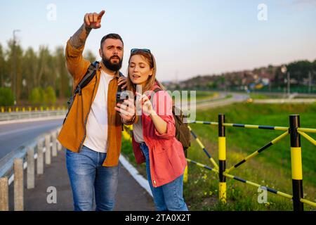 Tourists are using maps on smartphone in the city. They are sightseeing the city. Stock Photo