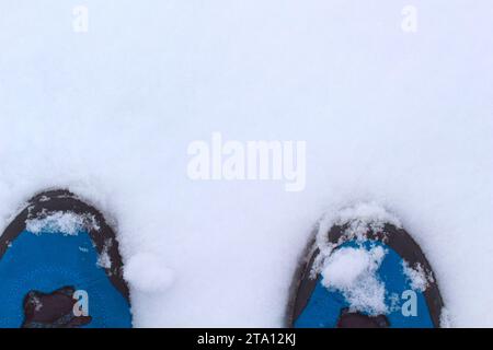 Blue hiking boots on clean white snow. Stock Photo