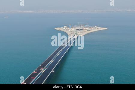 (231128) -- ZHONGSHAN, Nov. 28, 2023 (Xinhua) -- This aerial photo taken on Nov. 27, 2023 shows the west artificial island of the Shenzhen-Zhongshan link in south China's Guangdong Province. A cross-sea highway project between the cities of Shenzhen and Zhongshan in south China's Guangdong Province is one step closer to completion.   The last pouring of concrete was put in place on Tuesday, as work on the immersed tube underwater tunnel, which spans around 6.8 km, is nearing its end, said Guangdong Provincial Communication Group Co., Ltd.    The tunnel is part of a 24-km-long highway connectin Stock Photo