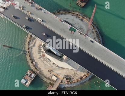 (231128) -- ZHONGSHAN, Nov. 28, 2023 (Xinhua) -- This aerial photo taken on Nov. 27, 2023 shows builders working on Lingdingyang bridge of the Shenzhen-Zhongshan link in south China's Guangdong Province. A cross-sea highway project between the cities of Shenzhen and Zhongshan in south China's Guangdong Province is one step closer to completion.   The last pouring of concrete was put in place on Tuesday, as work on the immersed tube underwater tunnel, which spans around 6.8 km, is nearing its end, said Guangdong Provincial Communication Group Co., Ltd.    The tunnel is part of a 24-km-long high Stock Photo