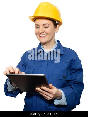 Isolated smiling woman engineer in yellow helmet and blue uniform with digital tablet. Stock Photo