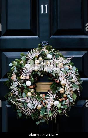 Downing Street, London, UK. 28th November 2023.  Christmas Decorations in Downing Street. Festive wreath adorns the famous black door of No 11 Downing Street. Photo by Amanda Rose/Alamy Live News Stock Photo