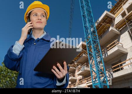 Female engineer with a digital tablet on the background of a building under construction.. Stock Photo