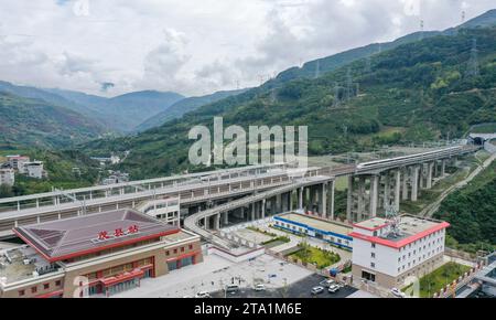 (231128) -- MAOXIAN, Nov. 28, 2023 (Xinhua) -- This aerial photo taken on Oct. 13, 2023 shows a train for commissioning and testing arriving at Maoxian railway station in Maoxian County, southwest China's Sichuan Province. A 238-km section of the Sichuan-Qinghai railway in western China became operational on Tuesday after 12 years of construction.   The railway crosses the rugged, earthquake-prone plateau region in northwest Sichuan, and takes a detour to avoid disturbing the Giant Panda National Park.      The Sichuan-Qinghai railway will eventually stretch northwestward to Xining, the capita Stock Photo
