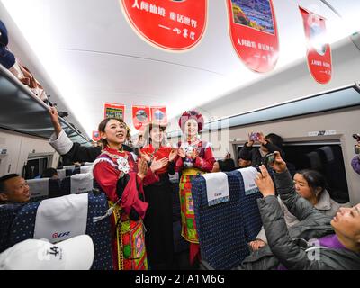 (231128) -- MAOXIAN, Nov. 28, 2023 (Xinhua) -- Performers sing on the first high-speed passenger train C6008 on a section of the Sichuan-Qinghai railway, Nov. 28, 2023. A 238-km section of the Sichuan-Qinghai railway in western China became operational on Tuesday after 12 years of construction.   The railway crosses the rugged, earthquake-prone plateau region in northwest Sichuan, and takes a detour to avoid disturbing the Giant Panda National Park.      The Sichuan-Qinghai railway will eventually stretch northwestward to Xining, the capital city of Qinghai Province. Upon completion of the who Stock Photo