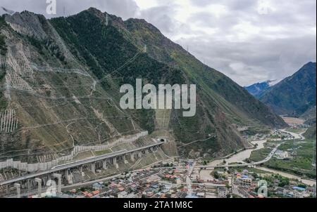 (231128) -- MAOXIAN, Nov. 28, 2023 (Xinhua) -- This aerial photo taken on Oct. 12, 2023 shows a train for commissioning and testing departing from Zhenjiangguan railway station in southwest China's Sichuan Province. A 238-km section of the Sichuan-Qinghai railway in western China became operational on Tuesday after 12 years of construction.   The railway crosses the rugged, earthquake-prone plateau region in northwest Sichuan, and takes a detour to avoid disturbing the Giant Panda National Park.      The Sichuan-Qinghai railway will eventually stretch northwestward to Xining, the capital city Stock Photo
