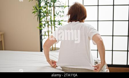 Middle age woman sitting on bed wearing pyjama at bedroom Stock Photo