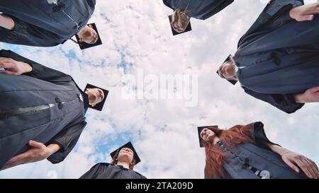 College students stand in a circle wearing black robes. Stock Photo