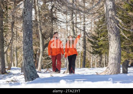 Happy couple enjoys a relaxing day outdoors in a stunning snowy landscape Stock Photo