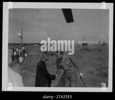 'American soldier engaging with Vietnamese civilians during the Vietnam War. The image captures a People to People interaction, showcasing an effort to establish relationships and provide support to local communities. This photograph was taken on July 24, 1962, during the early phases of American military involvement in Vietnam.' Stock Photo