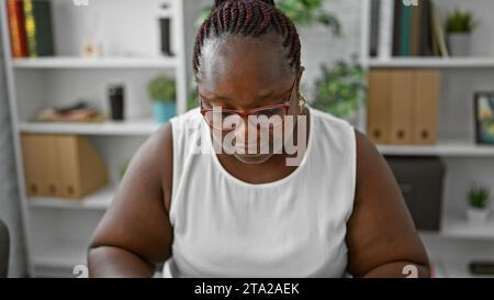 African american woman, a successful business worker, seriously concentrated, doubting an idea, faces down in the office. Stock Photo