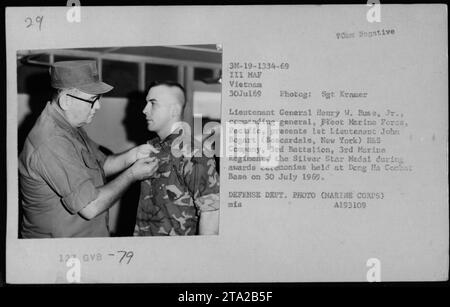 Lieutenant General Henry W. Buse, Jr. presents 1st Lieutenant John Bogart with the Silver Star Medal during a ceremony at Dong Ha Combat Base on July 30, 1969. The ceremony was attended by Assistant Secretary of the Navy John Warner, Secretary of Defense Melvin Laird, and Dr Norman Vincent Peale. Stock Photo