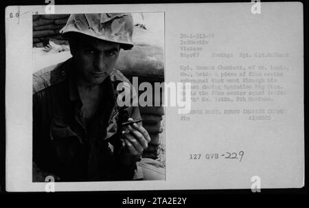 Cpl. Denne Checkett, from St. Louis, Missouri, holds a piece of 82mm mortar shrapnel that penetrated his helmet during Operation Big Hoan. He is the mortar squad leader of 'A' Company, 9th Marines, 3rd Marine Division, Vietnam, photographed on April 9, 1967, by Sgt. C.R. Helbert. This image is from the collection of American Military Activities during the Vietnam War. Contains Defense Department credit and identification information. Identifier: 60 30-1-515-67. Stock Photo