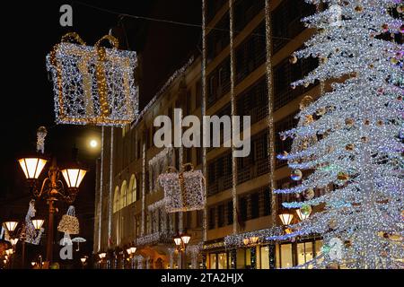 Budapest, Hungary - November 27, 2023: Beautiful shopping street scene with lamp post, glowing Christmas tree and lights and decorations. Stock Photo