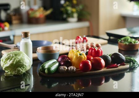 Closeup of set of food on kitchen table, focus on vegetables and bottle of milk Stock Photo