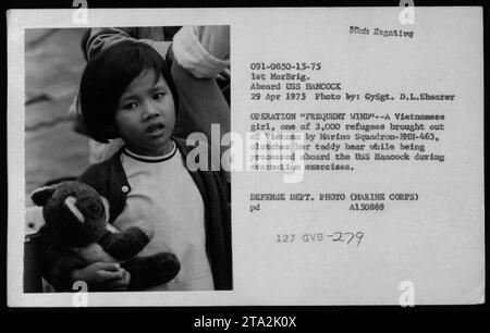 'Vietnamese girl aboard USS Hancock during Operation Frequent Wind, 1975. A member of the Marine Squadron HMH-463, she clutches her teddy bear while being processed as one of 3,000 refugees. Photo by GySgt. D.L. Shearer. Defense Department Photo (Marine Corps).' Stock Photo