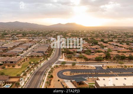 Aerial View Landscape Of Road And Mountain Buttes, Residential Area In Phoenix, Arizona On Orange Sunrise Or Sunset Sky. Arizona. National Arizona Day Stock Photo