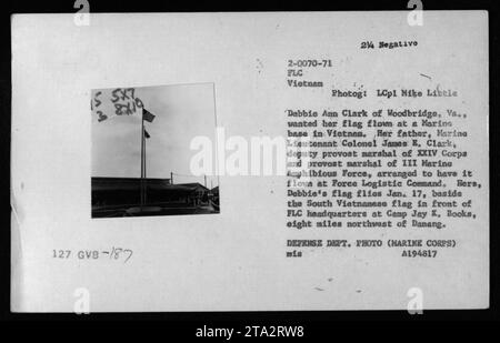 A flag ceremony takes place at Camp Jay K. Books, Vietnam, displaying a flag flown for Debbie Ann Clark, daughter of Marine Lieutenant Colonel James B. Clark. Lt. Col. Clark, the deputy provost marshal of XXIV Corps and provost marshal of III Marine Amphibious Force, arranged for the flag to be flown at Force Logistic Command. The flag flies alongside the South Vietnamese flag outside FLC headquarters on January 17. This photograph was taken by LCpl Mike Libele and is part of the Defense Department's collection of American military activities during the Vietnam War. Stock Photo