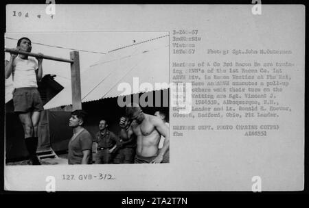 'ARVN soldiers from the 1st Recon Company of the 3rd ARVN Division are being trained in reconnaissance tactics at Phu Bai, Vietnam. In this photo, an ARVN soldier is seen performing a pull-up while others wait to take their turn on the bar. The soldiers waiting include Sgt. Vincent J. Rubio and Lt. Ronald E. Hoover. February 18, 1967.' Stock Photo