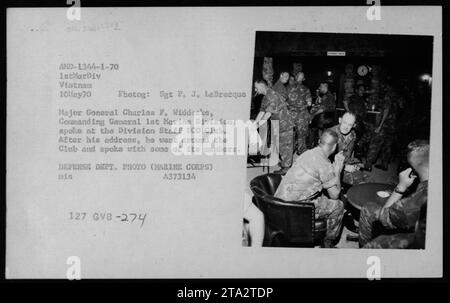 Major General Charles F. Widdecke, Commanding General of the 1st Marine Division, speaks at the Division Staff ICO Club in Vietnam on May 10, 1970. After his address, he engages in conversations with members of the club. This photograph captures a moment during the Vietnam War. Stock Photo