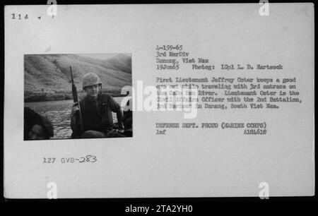 Marine Corps Civil Affairs Officer, First Lieutenant Jeffrey Oster, keeps a watchful eye while traveling with the 3rd antracs on the CaDe Son River in Vietnam on June 19, 1965. This photograph was taken by 10th platoon Le De Hartsock and is part of the US Department of Defense's collection. The image shows a military patrol during the Vietnam War. Stock Photo