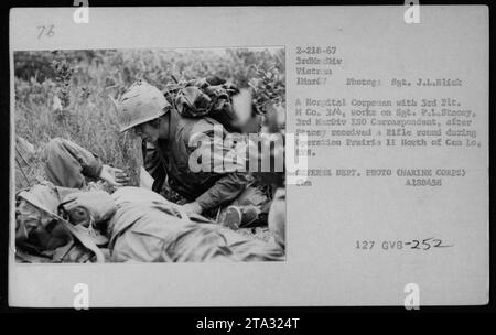 US Marine Corps personnel treat Sgt. P.L. Stacey, a 3rd MarDiv ISO Correspondent, after he was wounded by a rifle round during Operation Prairie II in Vietnam. The photograph shows a medic from the 3rd Platoon of H Company 3/4 applying medical aid. This image is from March 1, 1967. Stock Photo