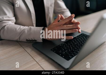 Closeup hands of unrecognizable pensive businessman sitting at desk with clasped palms thinking search problem solution, collect thoughts together Stock Photo