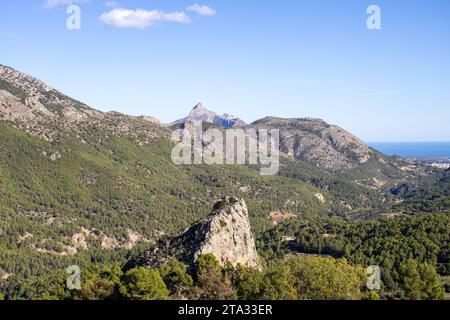 View of the sea and green tree-covered mountains from the castle at Guadalest, Spain Stock Photo