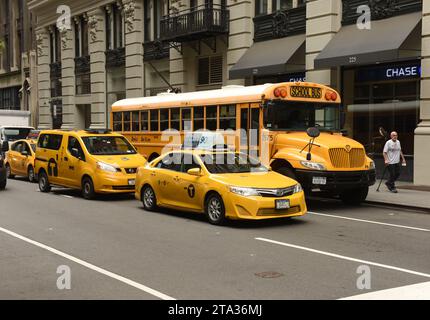 New York, USA - May 30, 2018: Yellow taxi and school bus on street of Manhattan in New York. Stock Photo