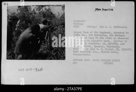 Caption: Sniper team from the 5th Regiment of the 1st Marine Division aim across Song Vu Gia river at observed Viet Cong on the opposite bank during the Vietnam War in 1968. The spotter is LCpl. D. R. Cronkite, while rifleman LCpl R. E. Bryant provides support. Photograph taken by Cpl R. J. DelVecchio. (Defense Department Photo - Marine Corps) Stock Photo