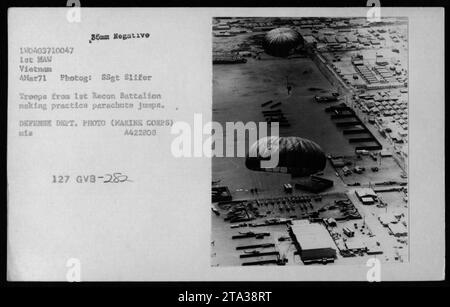 Troops from the 1st Recon Battalion of the US Marine Corps are seen in this photograph conducting parachute training exercises on March 4, 1971 during the Vietnam War. The soldiers can be seen packing their parachutes and preparing for practice jumps. The image is classified as Defense Department Photo (Marine Corps) and carries the label A422808 127 GVB-282 MEL TUGE. Stock Photo