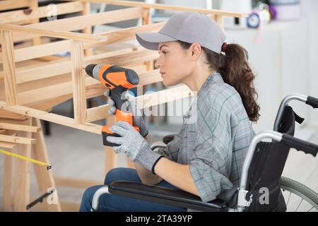 disabled worker in wheelchair working in a carpenters workshop Stock Photo