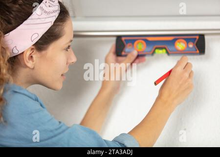 closeup of a blond young woman using spirit level Stock Photo