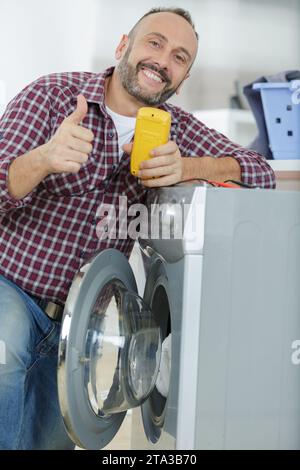 echnician checking machine with digital multimeter Stock Photo