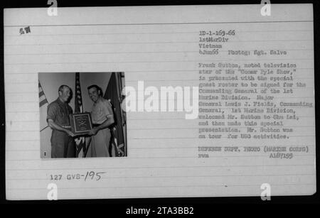 June 4, 1966: Television star Frank Sutton, known for his role on the 'Gomer Pyle Show,' is presented with a special guest roster to be signed by the Commanding General of the 1st Marine Division, Major General Louis J. Fields. Sutton was on a tour for USO activities and was welcomed by General Fields in Chu Lai. Defense Department photo (Marine Corps) A107195. Stock Photo