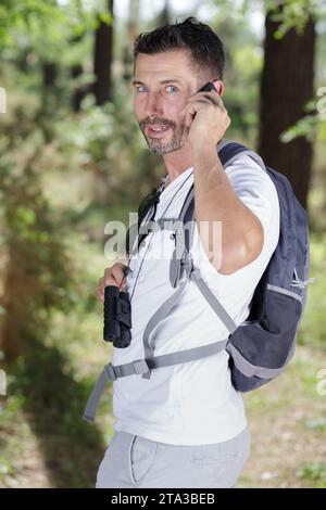 bird observer using his cellphone Stock Photo