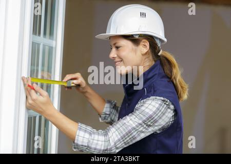 woman holding up a ruler and level marking a wall Stock Photo