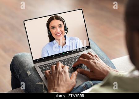 Black man using modern laptop with telecommunication screen at home Stock Photo
