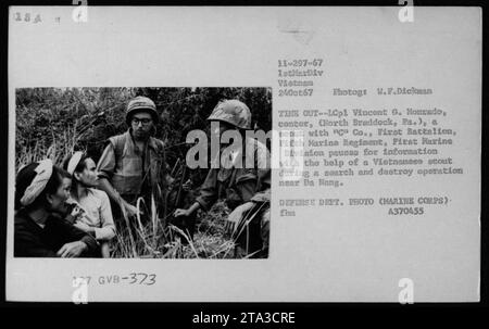 A scout from Cu Co, First Battalion, Fifth Marine Regiment, First Marine Division, named LCpl Vincent G. Monrado, along with a Vietnamese scout, paucas for information during a search and destroy operation near Da Nang on October 24, 1967. This photograph was taken by W.F. Dickman. Stock Photo