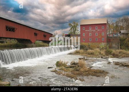 Bridgeton Covered Bridge (1914), Mill and Dam in Parke County in Bridgeton, Indiana under cloudy sky Stock Photo