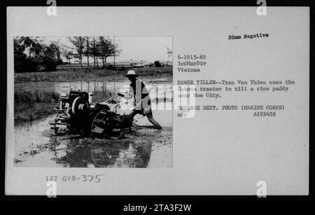 Vietnamese civilian Tran Van Thieu operates a Kubota tractor to cultivate a rice field near Hue City during the Vietnam War. The image is from 1969 and was captured by the Defense Department photographer, assigned to the 3rd Marine Division. Stock Photo