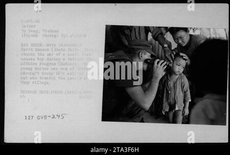 Lieutenant David Henson (Idaho Falls, Idaho) checks the ear of a small Vietnamese boy during a Medical Civil Affairs Program (MEDCAP) in Thuy village, Da Nang, Vietnam, on October 11, 1966. Henson, part of Aircraft Group 16's medical personnel, provided treatment to local villagers. This intense photo was taken by Corporal Johnson. Stock Photo