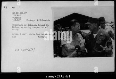 Secretary of Defense, Robert S. McNamara, inspecting MAG-11 during his visit to Vietnam in July 1967. Pictured alongside him are Vice President Hubert Humphrey, General William Westmoreland, and Senator Harry F. Byrd. This photo captures high-ranking officers and officials discussing military activities during the Vietnam War. Stock Photo