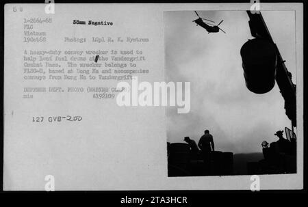 A heavy-duty convoy wrecker assists in loading fuel drums at Vandergrift Combat Base during the Vietnam War. The wrecker is operated by FLSG-D, stationed at Dong Ha, and accompanies convoys from Dong Ha to Vandergrift. This photograph was taken on October 19, 1968, by R. K. Nystrom. Stock Photo