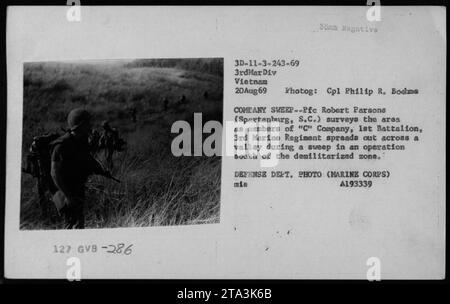 Members of 'C' Company, 1st Battalion, 3rd Marine Regiment conduct a sweep operation south of the demilitarized zone during the Vietnam War on August 20, 1969. Pfc Robert Parsons from Spartanburg, South Carolina surveys the area while the company spreads out across a valley. Stock Photo