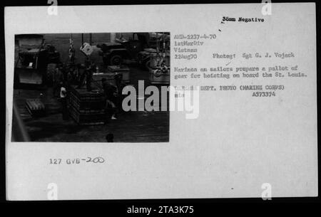 Sailors from the US Defense Department prepare a pallet of gear to be hoisted aboard the St. Louis in Vietnam. This photo was taken on August 22, 1970, by Sgt G. J. Vojack from the 1st Marine Division. The image is labeled as AMD-2237-4-70 1stMarDiv Vietnam. Stock Photo