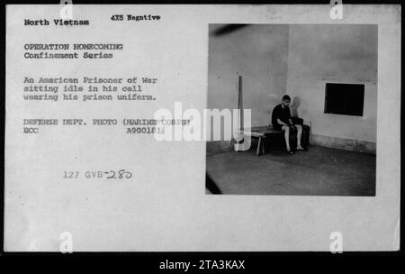 An American Prisoner of War sits idle in his cell, wearing his prison uniform during Operation Homecoming, the repatriation of US Marine POWs from North Vietnam during the Vietnam War. This photo captures a moment in the confinement series. (DEFENSE DEPT. PHOTO, MARINE CORPS) ECC A900181 127 GVB-280. Stock Photo