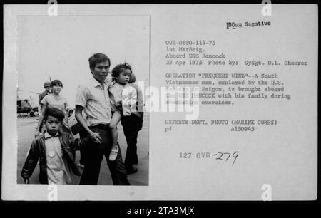 'Factual caption for Image: A South Vietnamese man, employed by the U.S. Embassy in Saigon, is brought aboard the USS Hancock with his family during the evacuation exercises of Operation Frequent Wind on April 29, 1975. The photo was taken by GySgt. D.L. Shearer of the 1st MarBrig. This image is part of the collection of photographs depicting American military activities during the Vietnam War.' Stock Photo